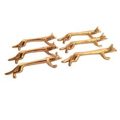 four gold plated animal clips on a white background