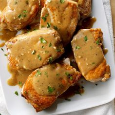 chicken covered in gravy on a white plate