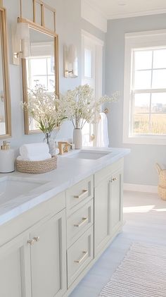 a white bathroom with two sinks and mirrors on the wall next to eachother