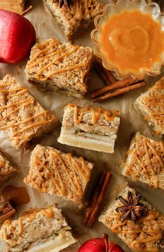 apple pie bars with cinnamon caramel sauce on the top and apples in the background