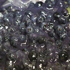 blueberries are sitting in a plastic container with water on it's surface, and they look like they have been frozen