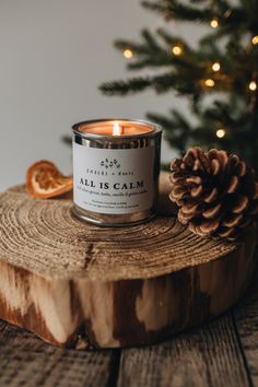 a candle sitting on top of a wooden table next to a pine cone