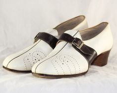 1930s ladies' shoes are classic Deco pumps in two-tone leather, with a tapered silhouette, functional buckle accent, and stacked wood heels.  These beautiful unworn authentic 30s shoes have pierced broguing and a piped center seam, with a pointed pinked tongue under the buckle strap.  From a drygoods store that opened in 1911.  Ladies' Size  Marked 8   Measurements  Ball of Foot Width 3 1/4, Toe to Heel Length 10 1/2 Inches   Era  1930s  Label  Size and style numbers stamped to lining, original 1930 Slippers, 30s Shoes, Sailor Shoes, 1930s Shoes, Ladies Pumps, Wood Heels, Monk Strap Shoes, Womens Pumps, Wood Heel