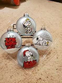 three glass christmas ornaments with snoopy on them