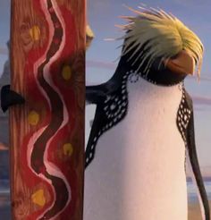 a penguin standing next to a wooden pole