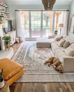 a living room filled with furniture and a large rug on top of a hard wood floor