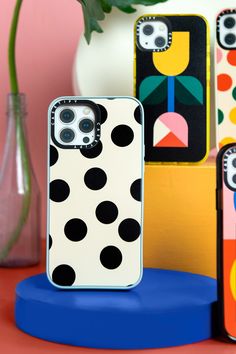 two cell phones sitting next to each other on top of a blue stand with polka dots