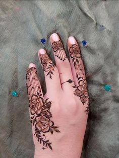 henna tattoo on the palm of a woman's hand with flowers and leaves