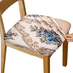 a chair with a cushion on it and a hand reaching for the seat back cover