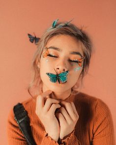 a woman with butterflies painted on her face