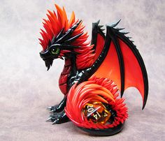 a red and black dragon figurine sitting on top of a table