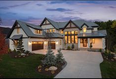 a large white house with lots of windows and lights on it's front porch