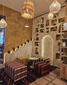 the interior of a restaurant with several tables and stools in front of a wall