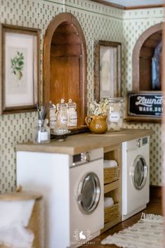 a laundry room with washer, dryer and mirror on the wall next to it