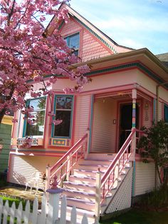 a pink house with stairs leading up to the front door