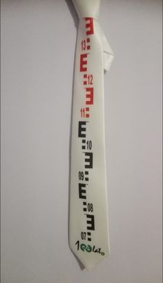 a white neck tie with chinese writing and numbers on the bottom side, tied to a wall