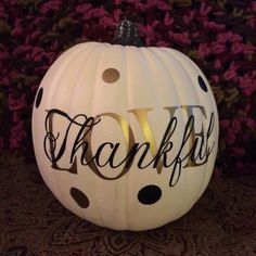 a white pumpkin with black polka dots and the word thank you on it's side