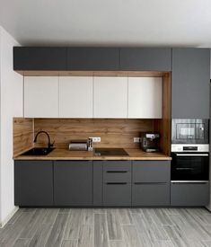 a kitchen with gray cabinets and white cupboards