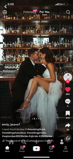 a man and woman sitting next to each other in front of a shelf full of liquor bottles