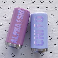 two pink and purple lighters sitting on top of a tablecloth covered surface with dots