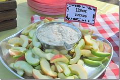 an apple platter with apples and dip in it on a checkered table cloth