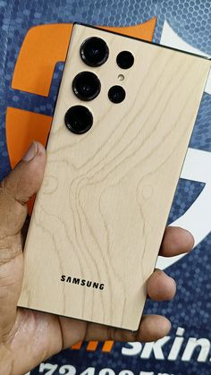 a person holding a wooden phone case in their hand