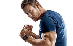 a man is flexing his muscles in front of a white background and looking at the camera