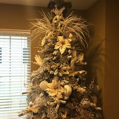 a decorated christmas tree in front of a window