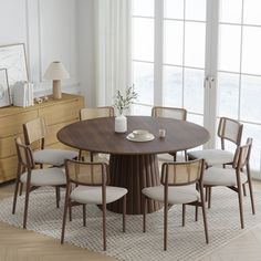 a round dining table with six chairs around it in front of a large window and white curtains