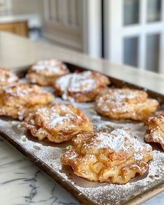 powdered sugar covered pastries are on a baking sheet, ready to be eaten