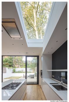 an open kitchen and dining room with skylights above the countertop, is shown in this modern home