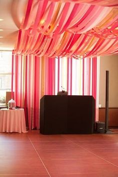 the room is decorated with pink and orange streamers