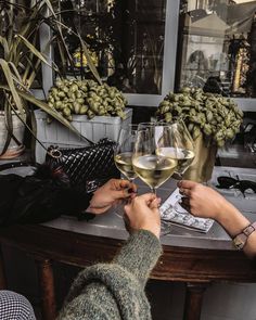 two people toasting with wine glasses on a table