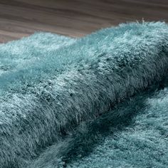 an area rug that looks like shaggy fur is laying on the floor with wood floors in the background