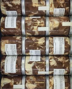 six packages of brown and white food are stacked on top of each other with labels