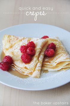 crepes with raspberries are on a white plate