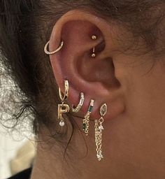 a woman wearing three different types of ear piercings