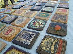 a table topped with lots of different types of coasters on top of a blue cloth