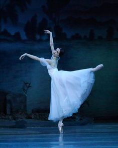 a ballerina in white is performing on stage