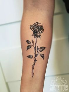 a black and white rose tattoo on the arm