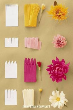 several different types of paper flowers on a brown surface with white and pink ones in the middle