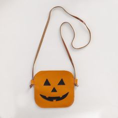 Our Pumpkin Lantern Handbag captures the spirit of Halloween with its intricate jack-o'-lantern design. Crafted from high-quality leather, this purse showcases a playful and friendly pumpkin face that's sure to bring smiles wherever your child goes. Leather Pumpkin, Pumpkin Lantern, Pumpkin Face, Lantern Design, Halloween Bat, First Halloween, Pumpkin Faces