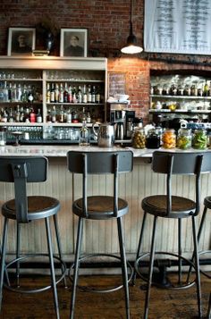 three bar stools in front of the bar