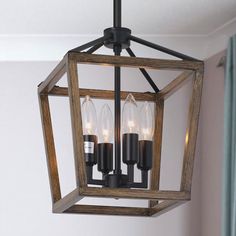 a light fixture hanging from the ceiling in a room with white walls and wood trimmings