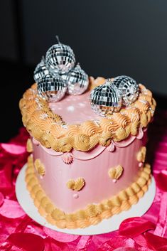 a pink and gold cake with silver decorations