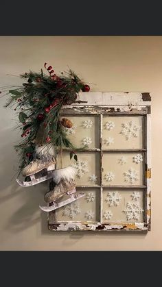 an old window is decorated with snowflakes and pine cones for the holiday season