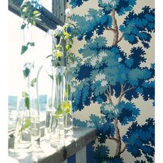 blue and white wallpaper with flowers in vases on window sill next to windowsill