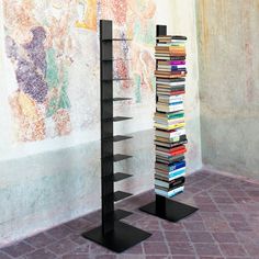 there is a tall book shelf with many books on it in front of a wall