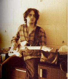 a man sitting on a chair holding a guitar