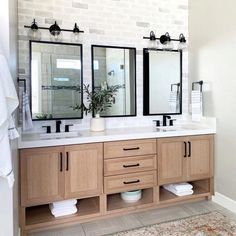 a bathroom with two sinks and three mirrors on the wall next to each other in front of a brick wall